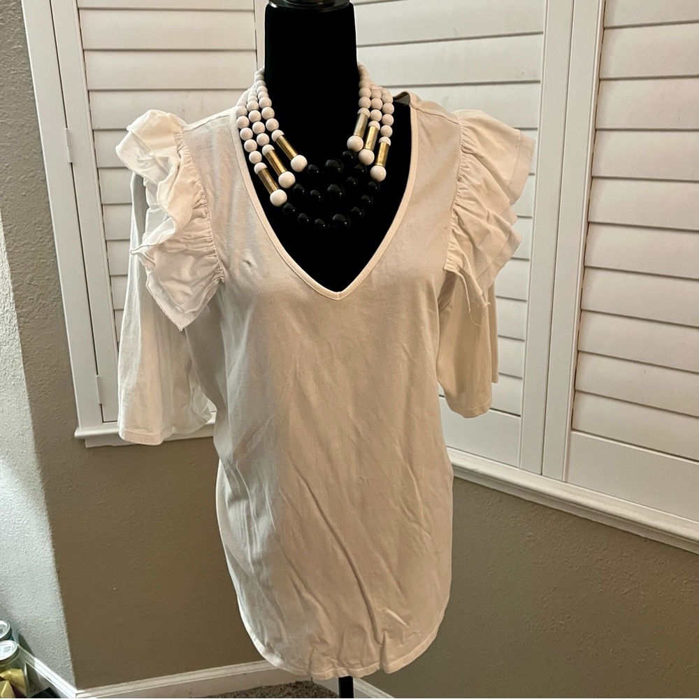White ruffle sleeve V-neck top with a relaxed fit.